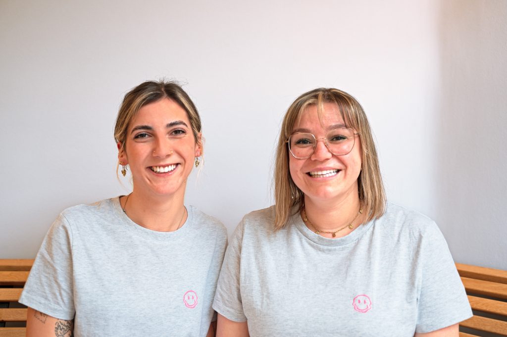 Zwei freundlich lächelnde Mitarbeiterinnen in der Praxis für Kieferorthopädie.