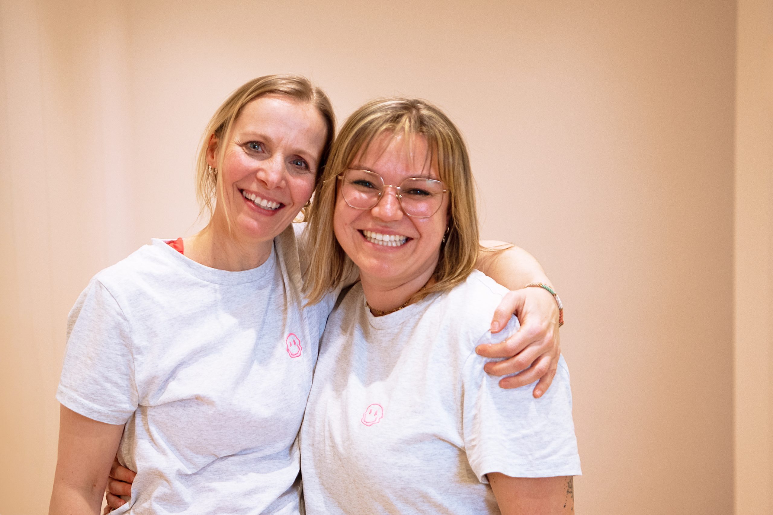 Dr. Susanne Güntzer hat eine Mitarbeiterin im Arm und beide lächeln.