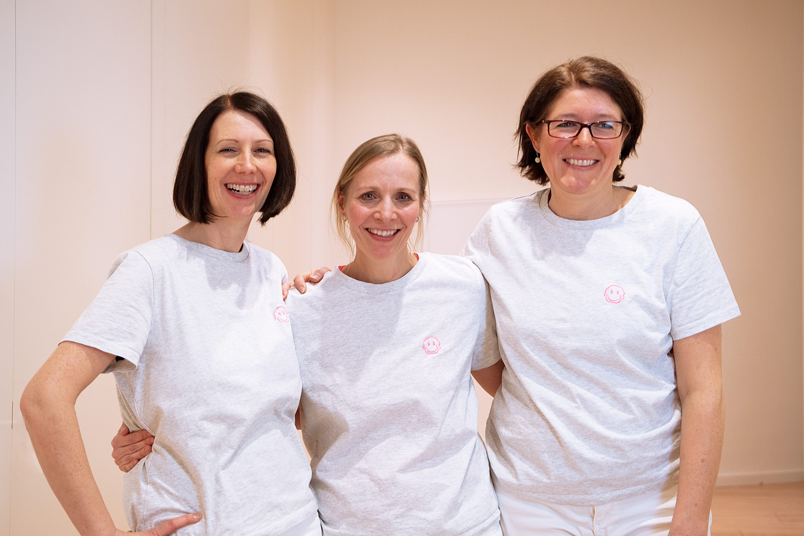 Dr. Susanne Güntzer steht Arm in Arm mit zwei Mitarbeiterinnen und lachen erfreut.